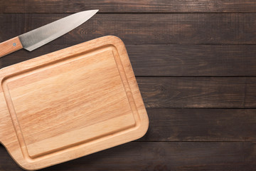 Knife and cutting board on the wooden background. 