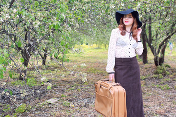 Obraz premium woman in retro dress outdoor suitcase park