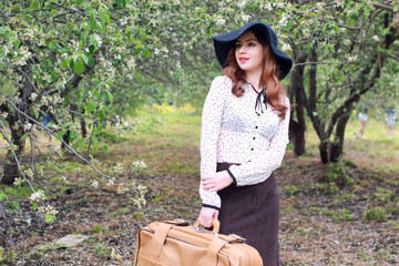 Obraz premium woman in retro dress outdoor suitcase park