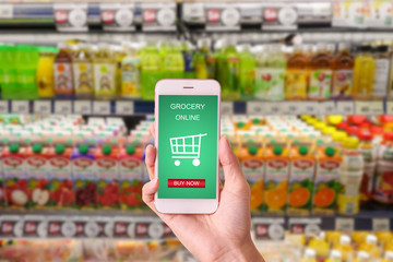 woman hand  holding mobile with grocery online on screen with blur supermarket background