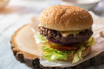 Burger on piece of paper. Grilled meat and fresh lettuce.