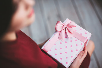 Female hands holding gift box.