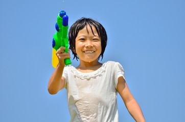 水鉄砲で遊ぶ女の子(青空)