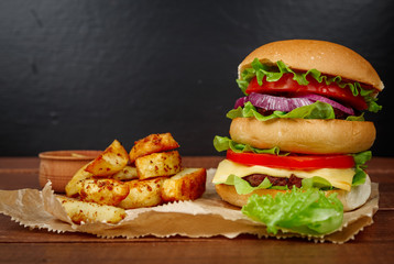 Big burger with fries on dark