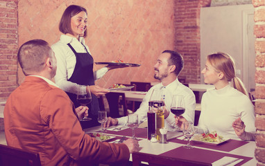 Waitress placing order in front of guests