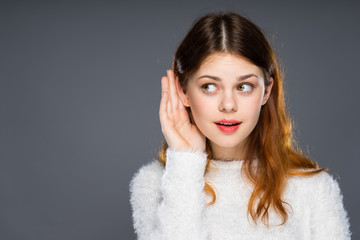 Close up portrait of attractive girl with red lips. Gossip girl eavesdropping with hand to ear....