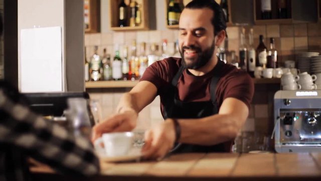 man or waiter serving customer in coffee shop