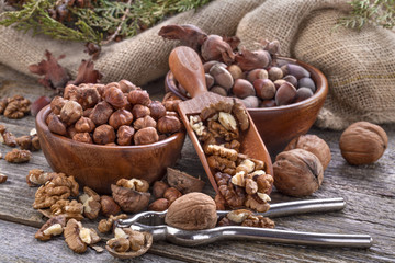 Hazelnuts and walnuts and a spoon on an old wooden table