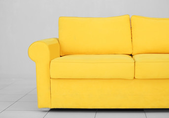 New cozy sofa on light wall background