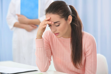 Young depressed woman at doctor's office