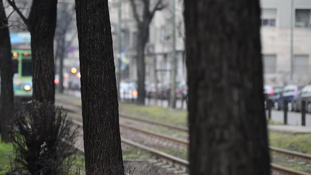 Tram di Milano pubblicitario arriva alla fermata con due ragazze che lo rincorrono alla fermata.