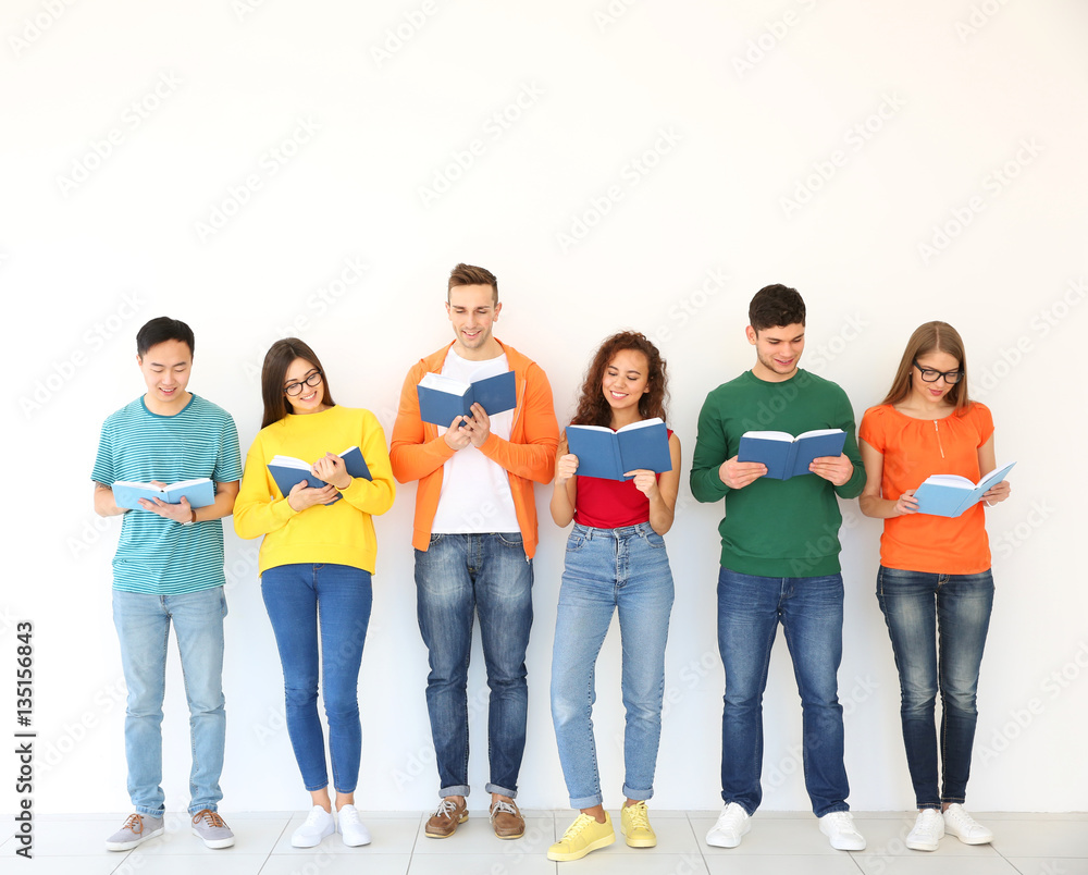 Sticker Group of people reading books while standing near light wall