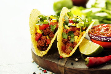 Mexican nachos chips and tacos with meat, beans and salsa