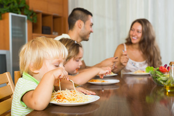 Family of four eating spaghetti