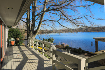 Large spacious deck of grey waterfront home - obrazy, fototapety, plakaty