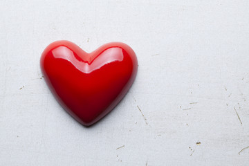 Blank wooden plate in wooden hand and red hearts in background