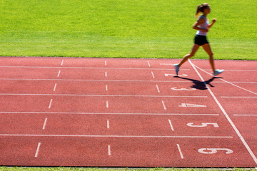 Runner on a running track finishing a race first (motion blurred)