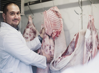 butcher working with meat in store.