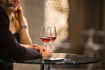 Man and a woman having drinks/glass of wine at a bar
