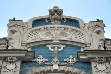 Facade of old building with sculptures of woman heads in Art Nouveau style (Jugendstil). Riga, Latvia.