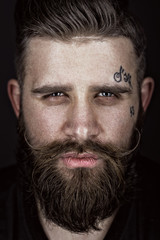 A solid man with a beard and mustache. Photos shot in the studio.