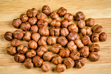 toasted hazelnuts without shells, on wood, background