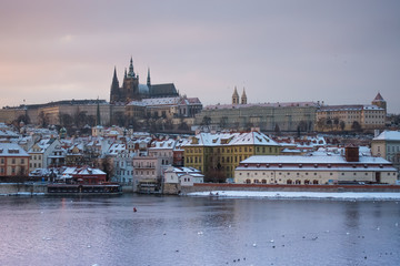 View of Prague castle and buildings under the snow from Charles Bridge