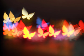 Colorful beautiful multi-colored Christmas blur butterfly lights on background. Glittering butterfly on bokeh background