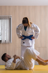 Woman and man judo fighters in sport hall