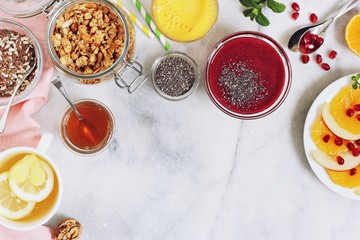Vegetarian breakfast table with berrie smoothie,granola, fresh juice and fruit salad.Super food and healthy eating concept.