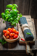 Ingredients for black spaghetti with basil and tomatoes