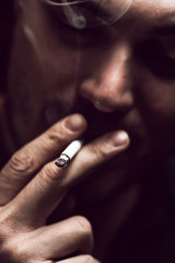 Cigarette addiction, closeup of young man smoking