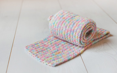 A colored knitted scarf on a white table 