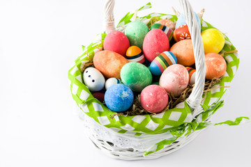 Colored easter eggs in a basket isolated on white background
