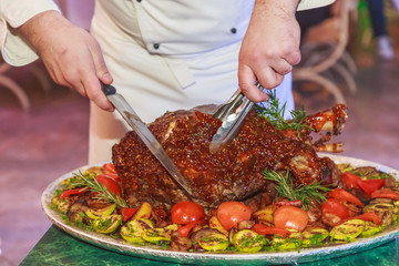 roast leg of pork in a dish with vegetables