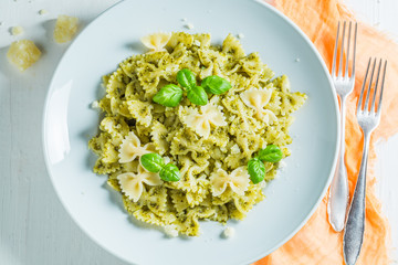 Tasty spaghetti with green pesto and basil