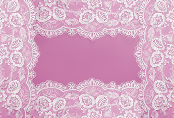 Invitation, greeting or wedding card with white lace on pink background.