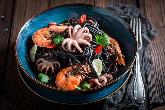 Tasty seafood black pasta made of octopus, tiger prawns
