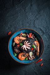 Fresh seafood black pasta made of octopus, tiger prawns