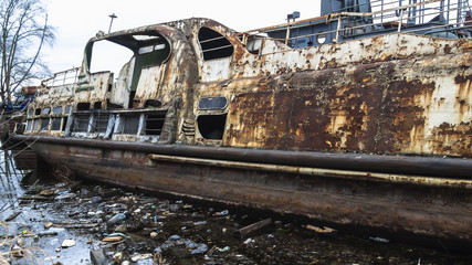 abandoned rusty ship in polluted river