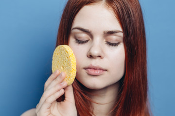 woman wiping her face with a soft sponge