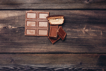broken chocolate tile and half pastry on a wooden background