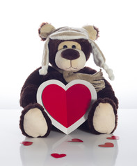 Obraz premium Teddy bear with heart card on a white background