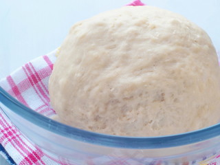 Cooking process. Preparing dough for cakes, pastries, buns or pizza. Leavened dough in transparent bowl. Close up image.