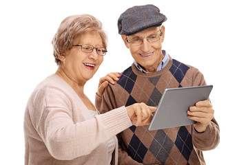 Happy seniors looking at a tablet