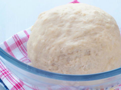 Cooking process. Preparing dough for cakes, pastries, buns or pizza. Leavened dough in transparent bowl. Close up image.