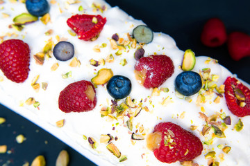 Cake with butter cream and raspberries on dark background
