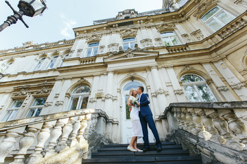 Obraz premium Man kisses blonde lady tender while they stand on footsteps outside