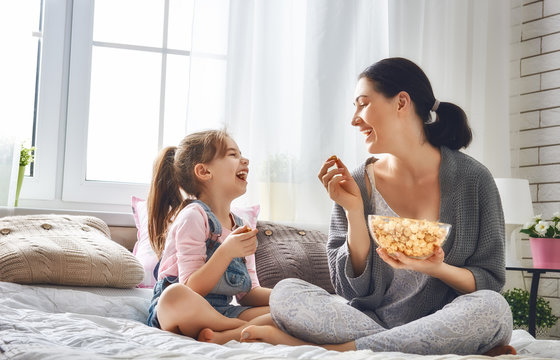 Mother And Daughter Eating Popcorn