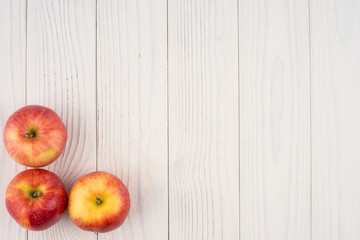 Red apples on the old wooden table.